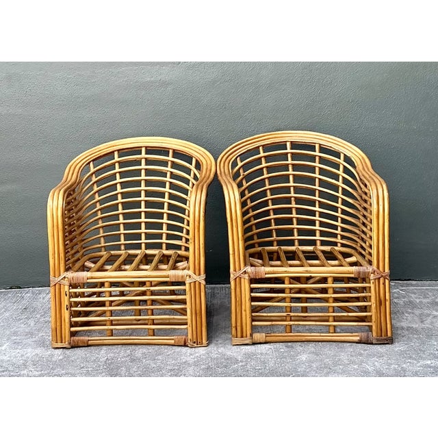 This pair of vintage stacked rattan lounge chairs brings the open, curved lines of mid-century seating to a matched set....