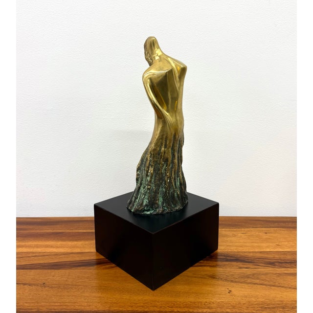 A graceful vintage modernist sculpture depicting a stylized female figure in an elegant, elongated pose. Cast in solid...