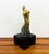 A graceful vintage modernist sculpture depicting a stylized female figure in an elegant, elongated pose. Cast in solid...