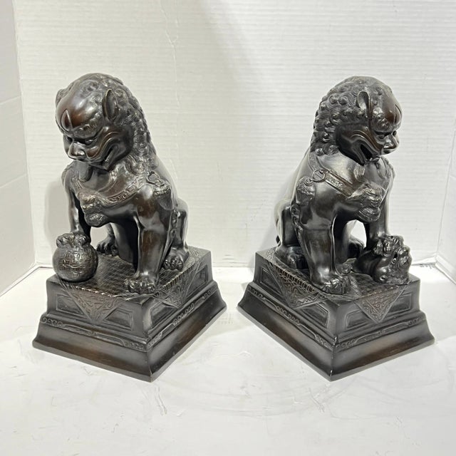 Vintage patinated metal figures of seated foo lions, each in excellent condition.