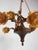Brass chandelier with figurative decoration of amoretto (putto), which symbolizes a child carrying a cornucopia. Florally...