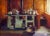 Warmth by Pam Ingalls | Oil on Board Interior scene with a stove and pots in warm tones. For Sale