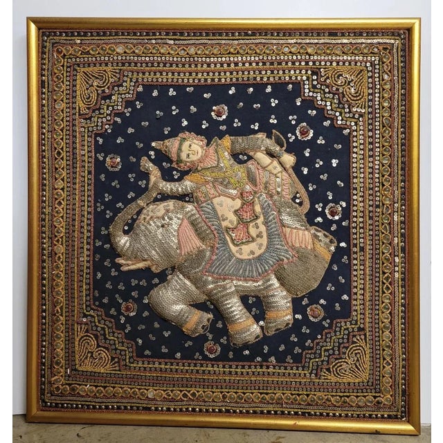 A wonderful antique Burmese tapestry featuring Loka-Nat riding an elephant. The padded figures are cut from cloth and sewn...