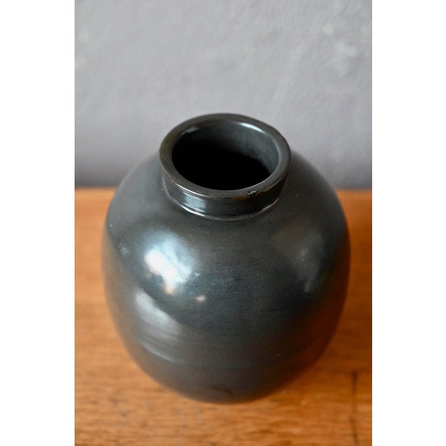 There is something profoundly seductive about this spherical vase: its black glaze with bluish and greenish reflections...
