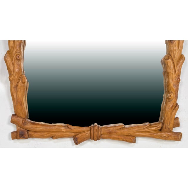 A carved wood mirror in the Black Forest style, ca. 1960s. Marked "Made in Italy". Gently tapers so that it is slightly...