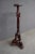 Carved mahogany pedestal or plant stand featuring an ornate tripod base, carved foliate and scroll details, and decorative...