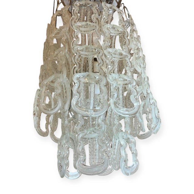 Large italian chandelier made of 60 white intertwined filaments of murano glass suspended at 18 chromed rods. Designed in...