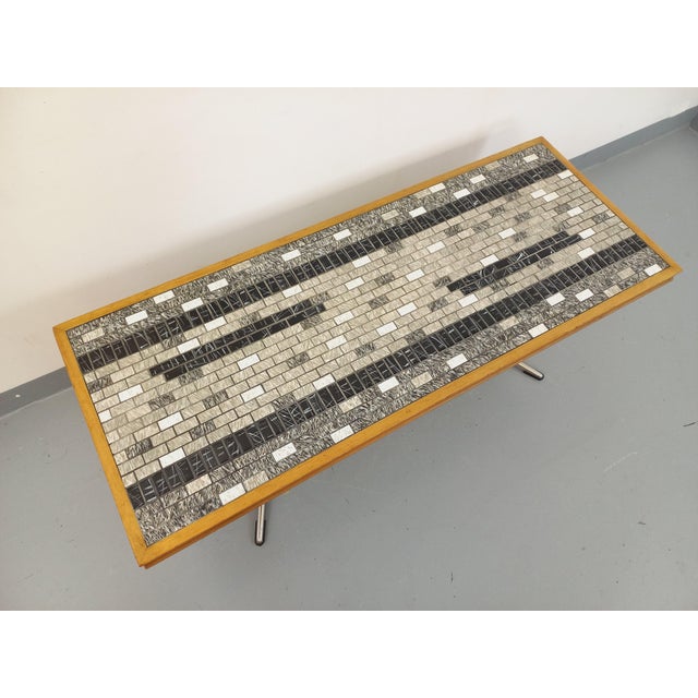 Vintage coffee table from the 60s and 70s. Top in light beech wood and small black white and gray marble effect ceramic...