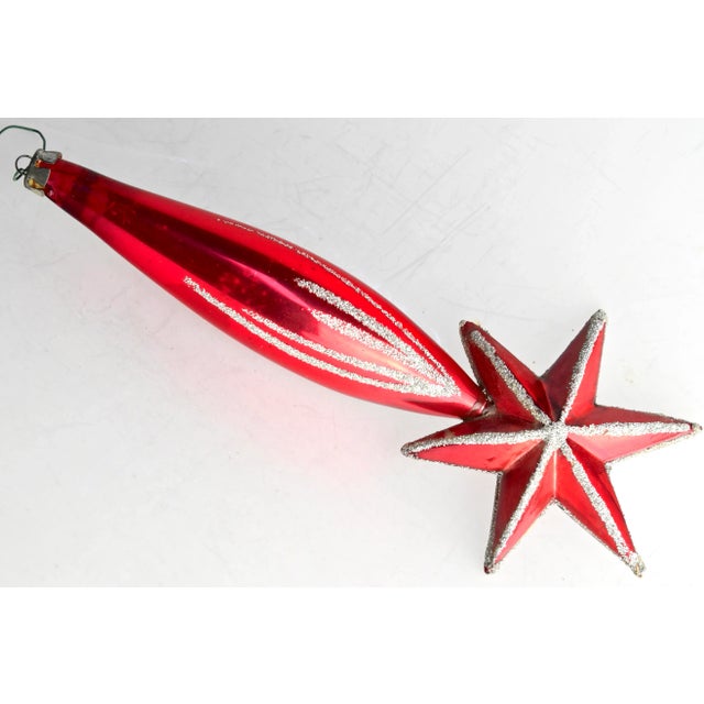 A dramatic midcentury mouthblown-in-mold mercury glass ornament in the shape of a shooting star, hand decorated with...