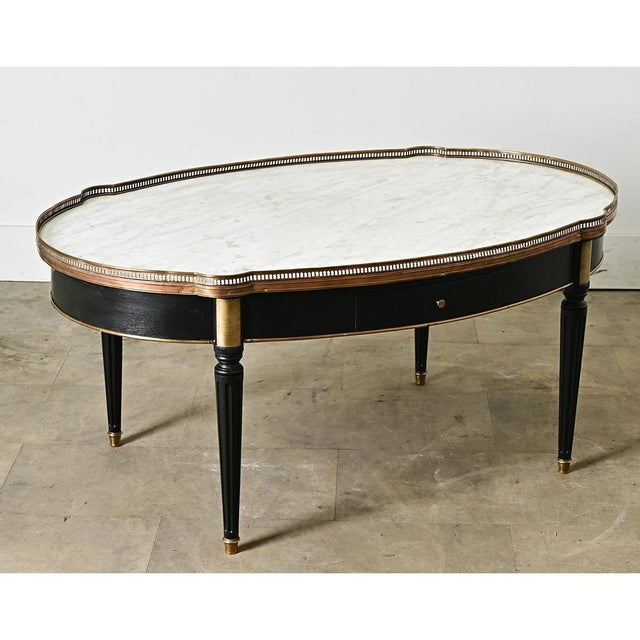 A French, 19th century Louis XVI-style oval form coffee table with the design features of bouillotte tables (the type made...