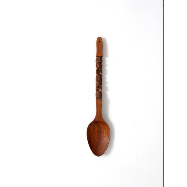 This is a mid 20th century large tiki style spoon. The folk carved serving spoon has a totem design with hole at top of...