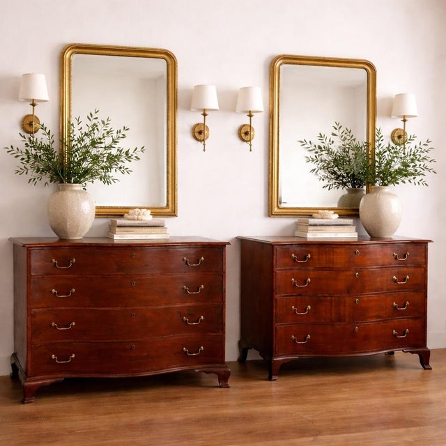 A beautifully assembled matched pair of Georgian mahogany serpentine-front chests of drawers, dating to the late 18th....