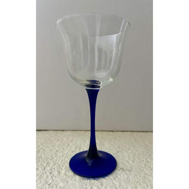 This glass is part of the "Americana Blue" pattern by Cristal d'Arques-durand. It features a clear, tulip-shaped bowl and...
