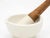 An early 20th century French white marble and pestle. The pestle has a wood handle and a stone base. Pestle measures 12"h...