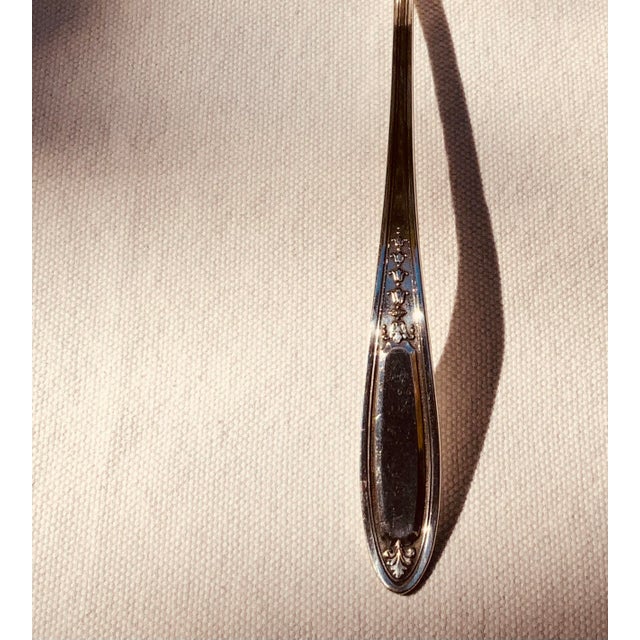 A graceful Oneida silverplate gravy ladle in a Neoclassical pattern, ten inches long. The tapering handle is crisply...