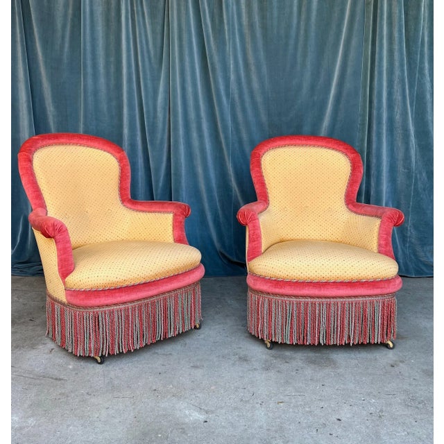 A unique and colorful pair of 19th century French Napoleon III armchairs upholstered in a golden yellow patterned fabric...