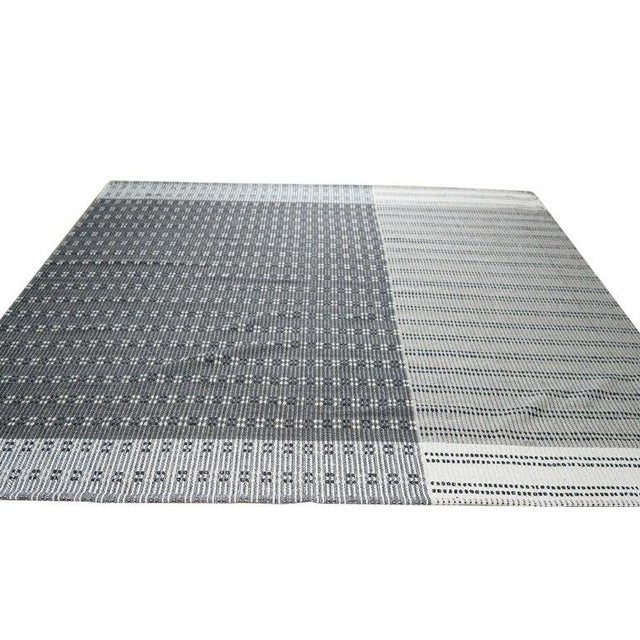 This hand knotted pile rug features a primary gray color and is crafted from a durable blend of cotton and wool....