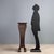 Walnut vase stand. Square top supported by two molded legs, the front one carved, central joint, feet with feral carvings....