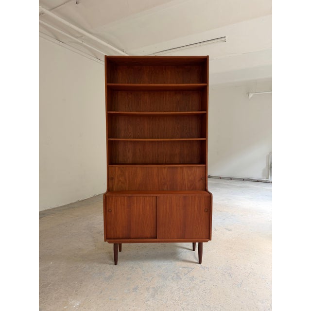 This 2-meter-high teak bookcase is a classic example of Danish furniture craftsmanship from the 1950s. with its...