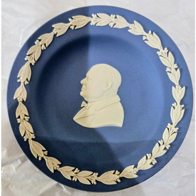 This vintage Wedgwood blue jasperware small plate features a white relief profile of Winston Churchill framed by a...