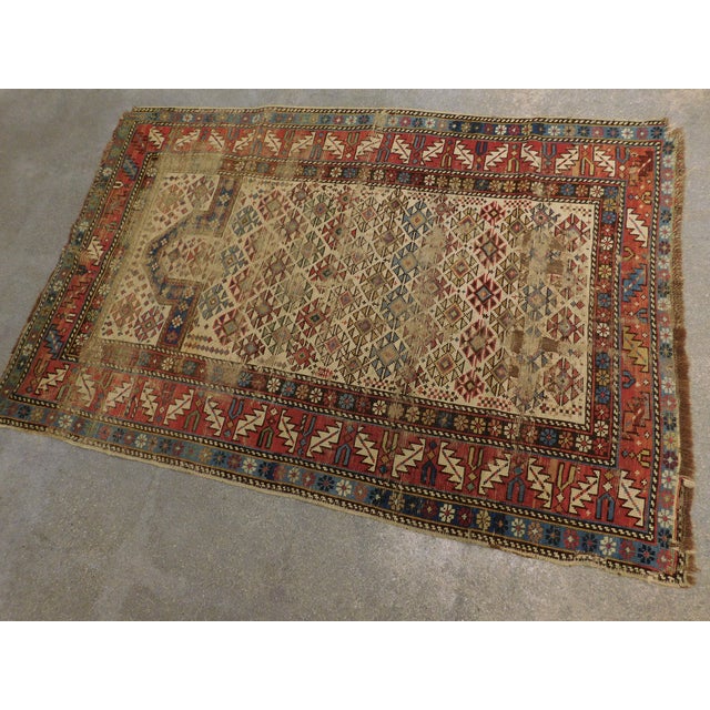 Geometric motifs on a beige background under a blue prayer niche. Main border in rust. 100% wool. Circa: 1900 Hand...