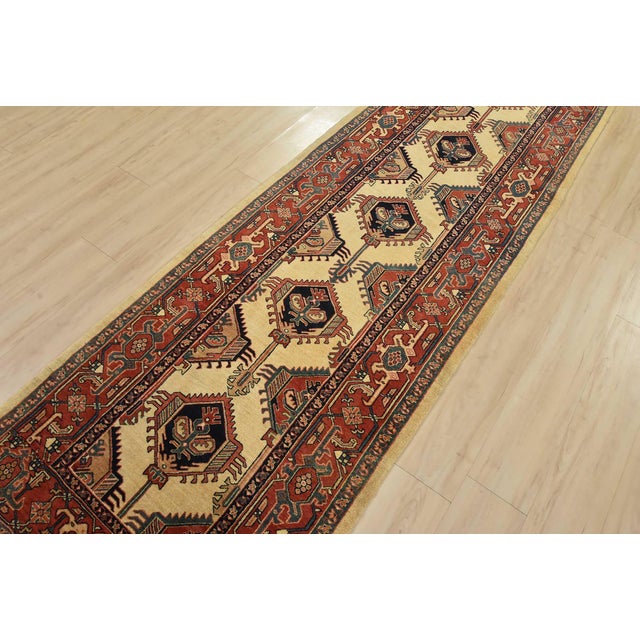 An authentic vintage tribal Heriz runner hand-knotted with fine wool and silk highlights and natural dyes. This...