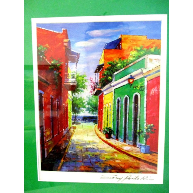 Vibrant and colorful print of a street in Puerto Rico entitled "Sunny Puerto Rico." Displayed in a double mat in a white...