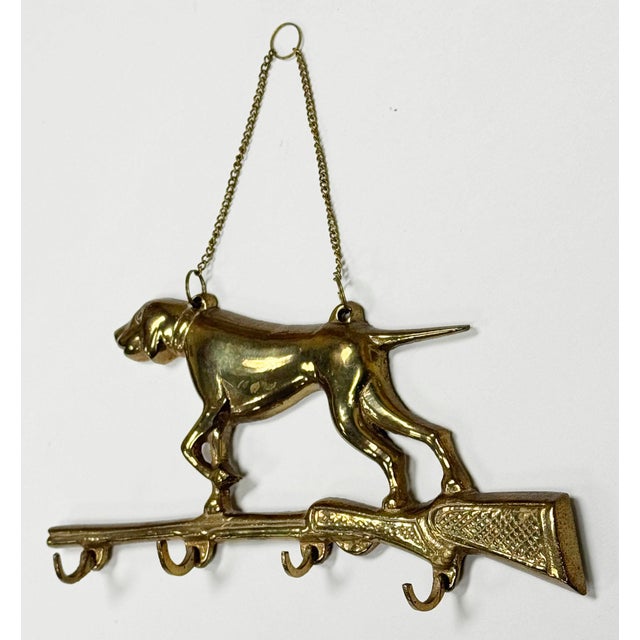 Vintage brass hunting dog key holder wall hook featuring a pointer dog atop a hunting rifle with four (4) hooks for keys....