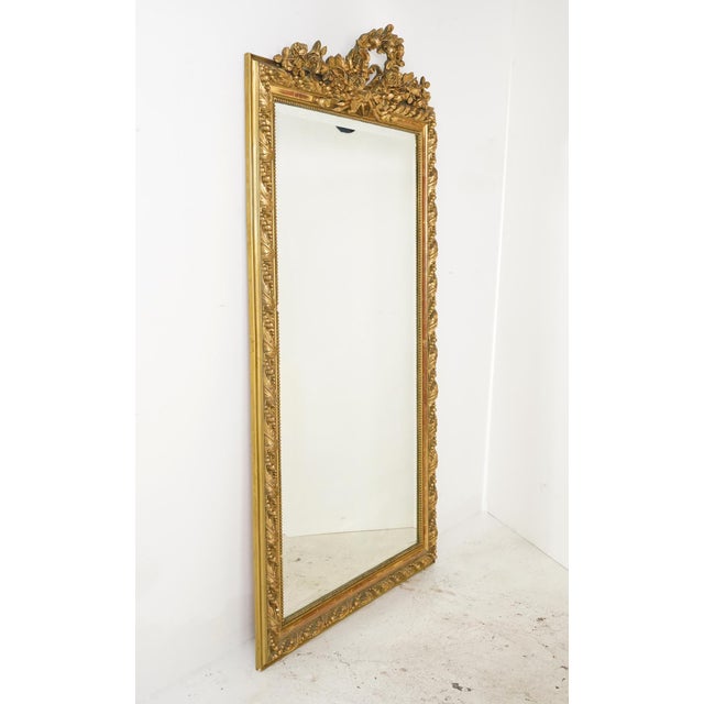 Antique French made Louis XVI giltwood wall mirror. It features the key Louis XVI traits of ornate detailing on the carved...