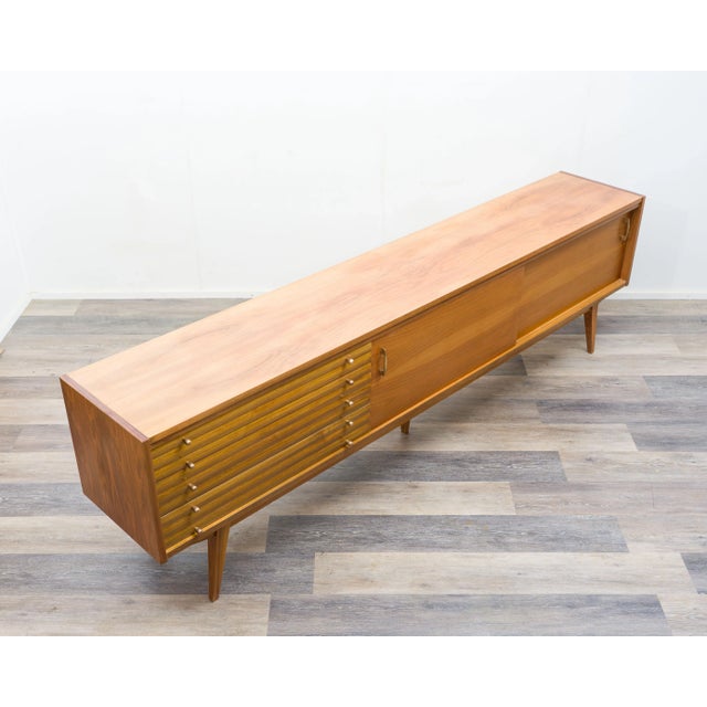 A very large, custom-made walnut sideboard from the 1950s. Elegant, sleek design features three large drawers on the left...