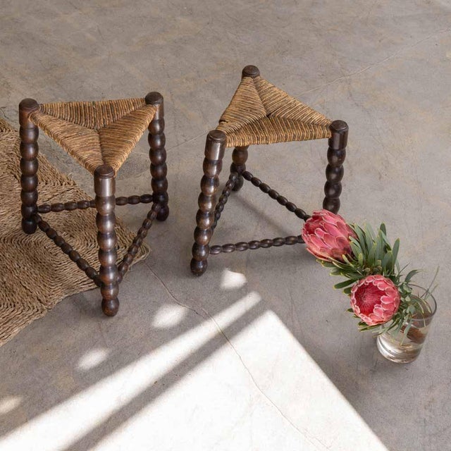 Beautiful pair of bobbin wood and woven stools from France, 1940s. Three dark carved bobbin wood legs with original...
