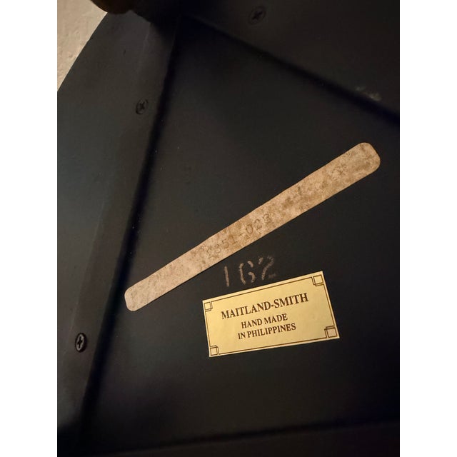 Elegant Maitland-Smith pedestal plant stand has a black finish with gold-toned accents. This handmade piece from the...