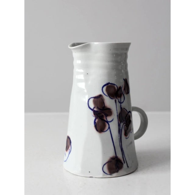 This is a vintage studio pottery pitcher. Signed by the artist, the hand-crafted ceramic ewer features a low setting...