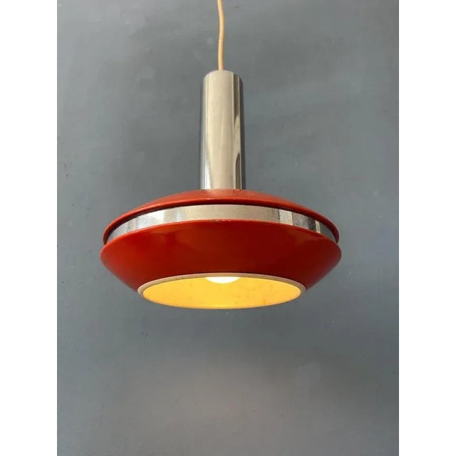 Small red vintage space age pendant lamp with chrome accents. The shade is made out of metal and has an red colour. The...