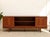 A handsome vintage teak credenza featuring a warm, rich wood finish and a beautifully streamlined silhouette. The design...