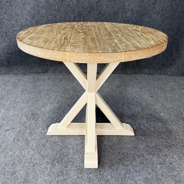 This rustic round side table features a distressed oak plank-style top with visible grain and character markings. The...