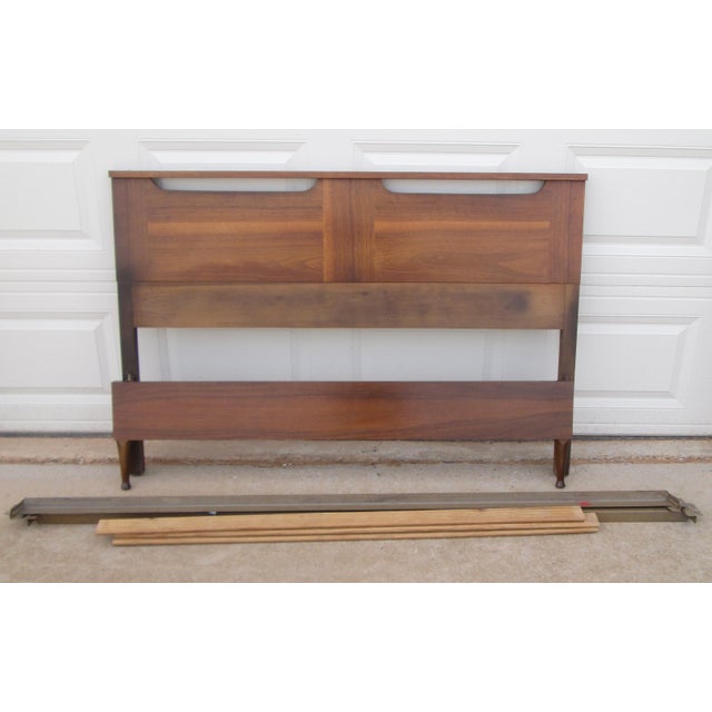 Vintage mid century modern walnut bed including headboard, foot board, metal side rails and cross boards. The headboard...