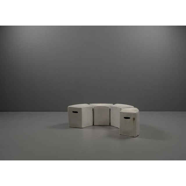 The 4 postmodern stools made of glazed enamelled ceramic in natural white, with recessed handles on the left and right....