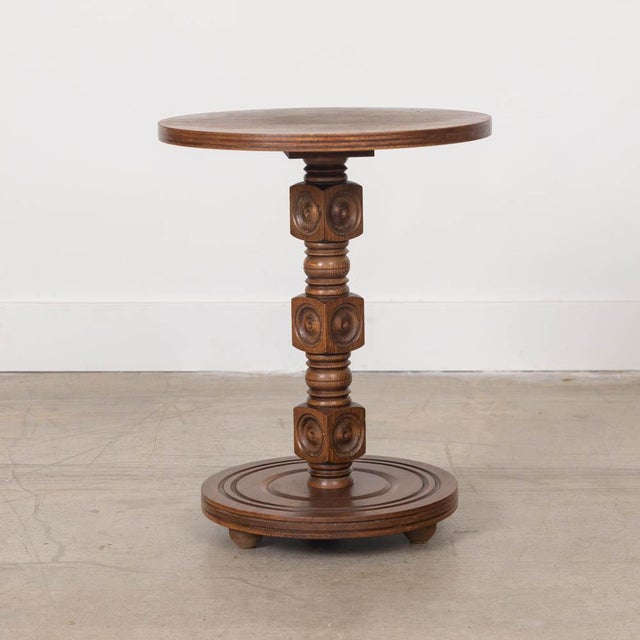 Petite carved wood table by Charles Dudouyt, made in France, 1940s. Thick carved wood block stem with circular top and...