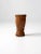 A antique carved wood mortar, sculpted in a tall, slender form with beautifully craggy contours. The naturally weathered...
