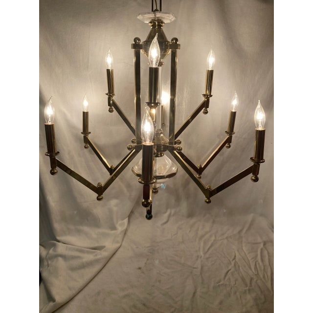 Unmarked Mid Century Modern brass and lucite chandelier that has an angular desi with brass balls accents. Has a lucite...