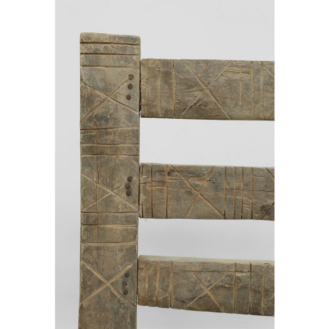 Antique low chair constructed from hand-carved wood with a leather woven seat. Features turned front legs, an...