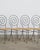 Set of four vintage iron spiral chairs with a wicker seat, purchased from a gallery in NYC. 37” h 16” w 16” d