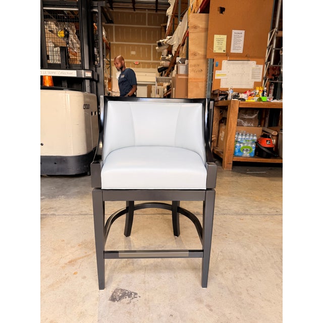 Contemporary barrel-style counter stool featuring sky blue leather upholstery framed by a rich onyx wood finish for a...