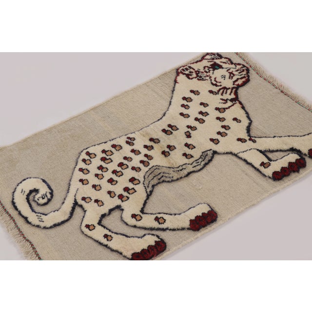 Hand-knotted in wool and originating circa 1950-1959, this 2x3 vintage Gabbeh pictorial gift-sized rug is from Afghanistan...