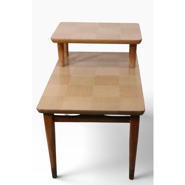 Classic 1950's step end tables featuring faux wood veneer formica checkerboard surfaces, with tapered pole wood legs. Both...