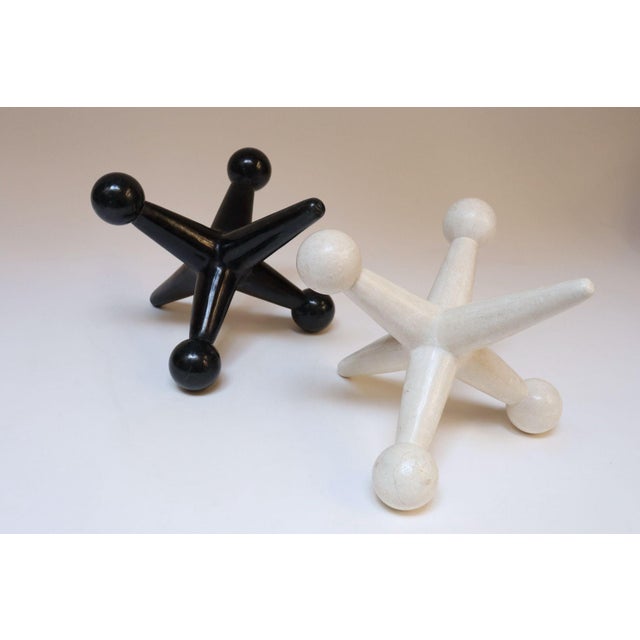 Set of two Hollywood Regency-Style jax/jacks sculptures composed of tessellated stone - one black, one beige, made for the...