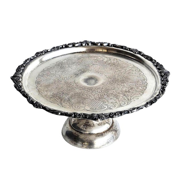 Offered is a vintage silver-plated pedestal cake stand by Sheridan Silver Co.. It features a decorative, scalloped rim...