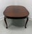 A Queen Anne style oval dining table by Henkel Harris, of Winchester, Virginia, USA. Solid mahogany with rounded edge to...