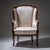 Louis XV style wingback armchair with Rococo-inspired bronze rocaille motifs along the frame. The chair is upholstered in...